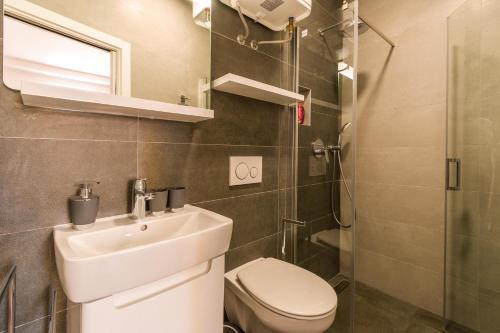 a bathroom with a sink and a toilet and a shower at Apartman Nika in Pula