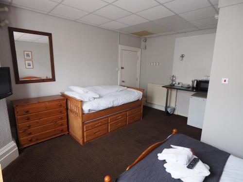 a hotel room with two beds and a mirror at Richmond House in Southport