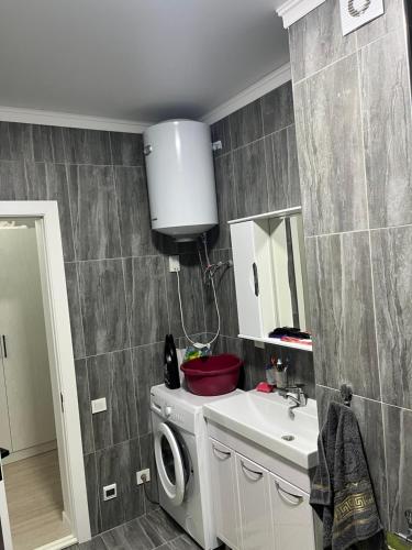 a bathroom with a washing machine and a sink at Берег3 in Bosteri