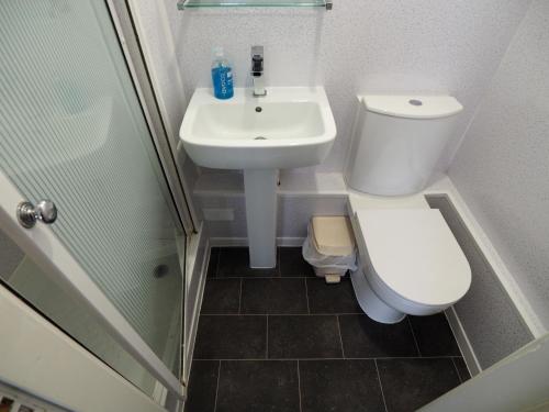 a small bathroom with a toilet and a sink at Richmond House in Southport