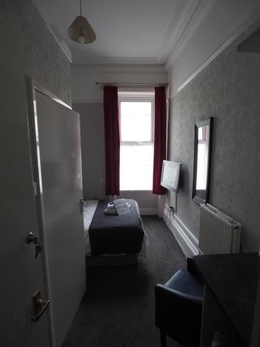 a hotel room with a bed and a window at Richmond House in Southport