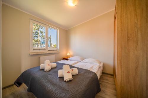 a bedroom with two beds with white towels on them at Apartamenty Gromada Międzyzdroje in Międzyzdroje