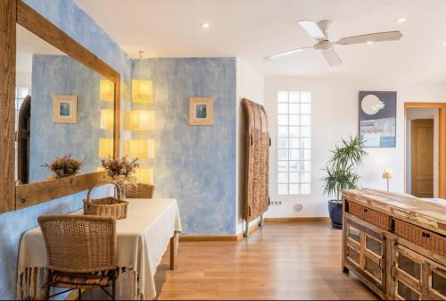 a dining room with a table and a blue wall at Disfruta del mar antes de que lleguen las multitudes in L'Escala