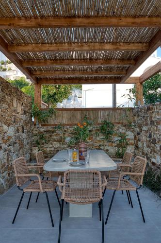 a table and chairs under a wooden pergola at Clementina Paros in Naousa