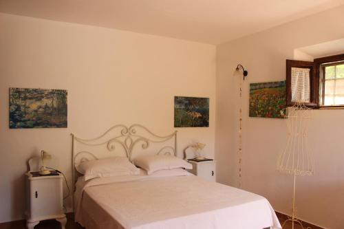 a bedroom with a bed and paintings on the wall at Agriturismo la Lecciola in Rio nellʼElba