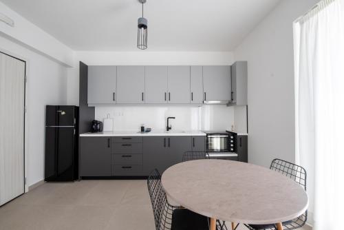 Ennea suites-Space suite في Flámbouras: مطبخ مع طاولة وثلاجة