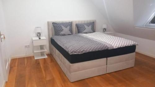 a bed in a white room with a bed frame at Luxuriöse Wohnung im Herzen von RLP in Bobenheim-Roxheim