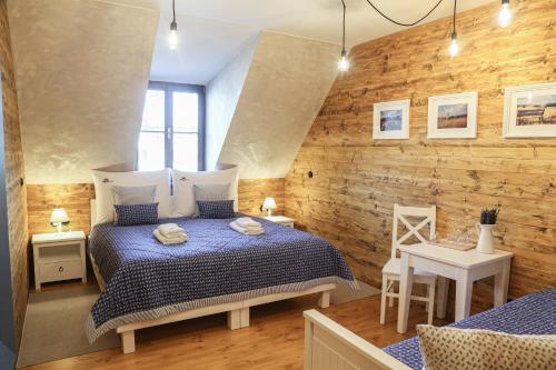 a bedroom with a bed and a wooden wall at Pension Angusfarm in Soběsuky