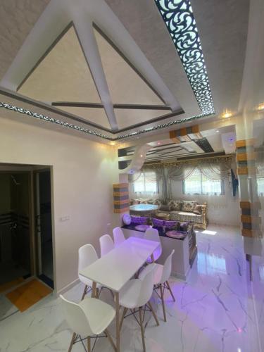 a dining room with a white table and chairs at Appart Hicham in Tangier