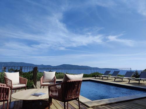 un patio con mesa y sillas y una piscina en Résidence La Plage en Propriano