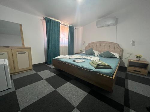 a bedroom with a bed and a checkered floor at Vila Alemary in Năvodari