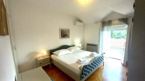 a bedroom with a bed and a large window at ALMA in Makarska