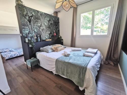 une chambre avec un lit et une grande fenêtre dans l'établissement Villa Milea - Lège Cap-Ferret, à Lège-Cap-Ferret