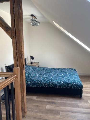 a bed with a blue comforter in a room at Duplex hammam au pied de la Cathédrale avec vue in Reims