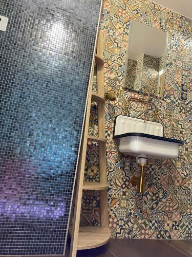 uma casa de banho com um lavatório e uma parede em mosaico em Duplex hammam au pied de la Cathédrale avec vue em Reims