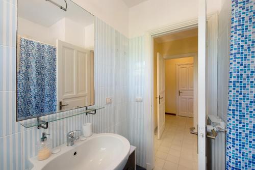 ein weißes Badezimmer mit einem Waschbecken und einem Spiegel in der Unterkunft Villa Roberta in Arenzano