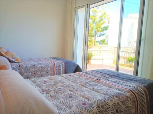 アルカナルにあるCasa Ginesta - Flamenc (near the beach)のベッドが2つと大きな窓がある寝室