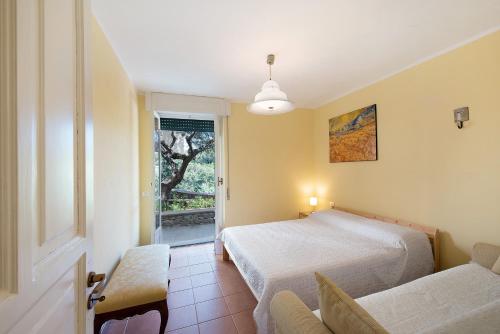 um quarto com uma cama, uma cadeira e uma janela em Villa Roberta em Arenzano