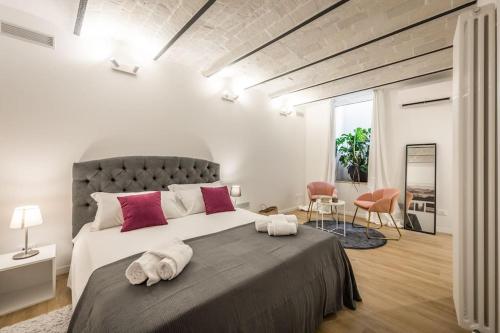 Santo Stefano Apartment with private Garden في بولونيا: غرفة نوم بسرير كبير عليها منشفتين