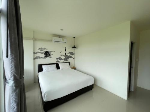 a bedroom with a white bed in a room at Dwell Phuket Airport Hotel at Naiyang in Nai Yang Beach