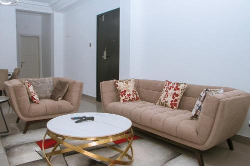 a living room with two couches and a coffee table at Candide Guest House in Limbe