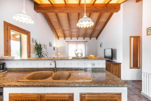 una cucina con lavandino e soffitto in legno di Finca Can Petit - Apartamento rural a Capdepera