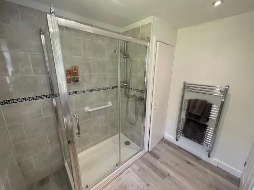 a shower with a glass door in a bathroom at Railway Cottage - Pet friendly with parking in Ripon