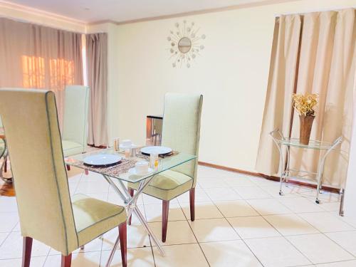a dining room with a glass table and chairs at Siena Sun Guesthouse Rooms and Breakfast Option in Midrand
