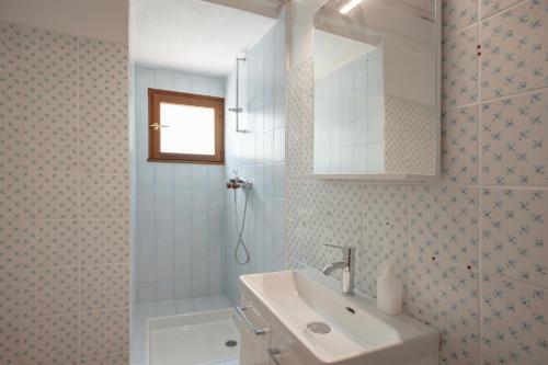 a white bathroom with a sink and a shower at U Prato - Bungalow proche de la mer in Lumio