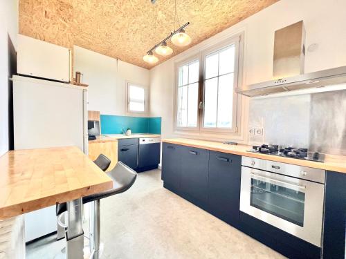 une cuisine avec des placards bleus et une table en bois dans l'établissement Les hauts de tison ~ Vue sur la vallée du Clain, à Poitiers