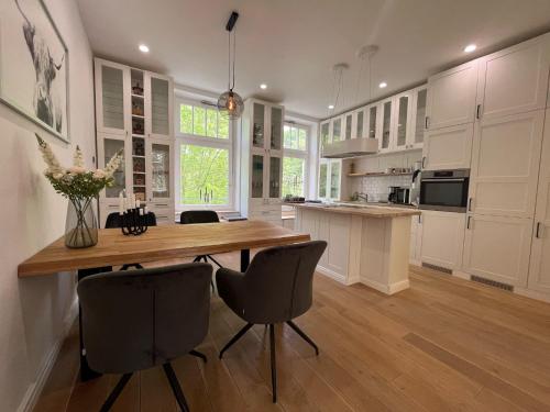 une grande cuisine avec une table et des chaises en bois dans l'établissement Prinzenhof Suite, à Bad Harzburg