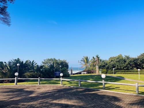 a park with a fence and trees and the ocean at Santana 804 Beachfront Apartment with spectacular sea views in Margate
