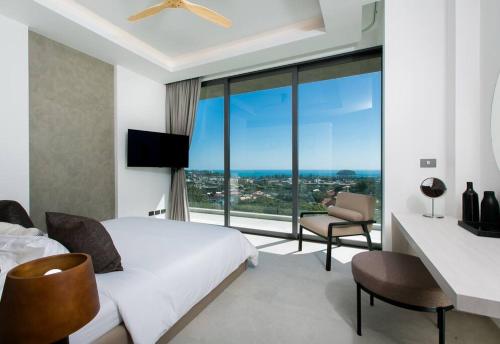 a hotel room with a bed and a large window at Villa Nordic Star Seaview Near Kata Beach in Kata Beach