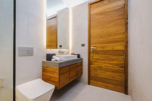 カタビーチにあるVilla Nordic Starのバスルーム(トイレ、シンク付)、木製のドアが備わります。