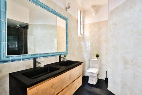 a bathroom with a sink and a toilet and a mirror at Arc de Triomphe Superbe Appartement Paris in Paris