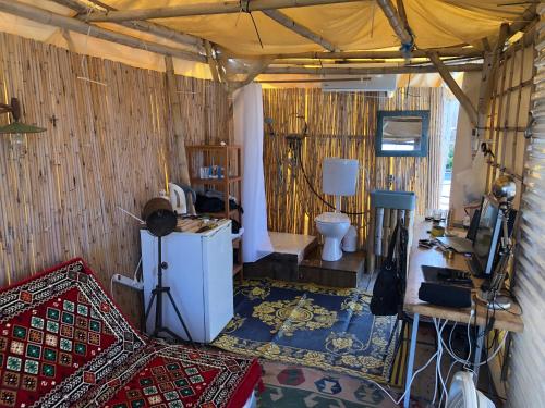 a room with a refrigerator and a toilet in a tent at קמפינג על הגג ביפו in Tel Aviv