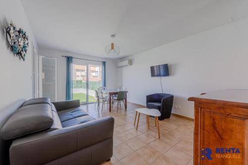 a living room with a couch and a table at La Perle WIFI Plain Pied Proche Mer in Saint Cyprien Plage