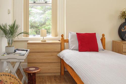 - une chambre avec un lit doté d'un oreiller rouge dans l'établissement Lotus Studio near Lanark, à Carstairs
