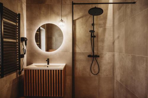 a bathroom with a shower and a sink and a mirror at OSADA LEŚNA - domki z basenem in Stare Miasto