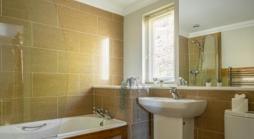 a bathroom with a sink and a tub and a toilet at Cunsey Lodge in Far Sawrey