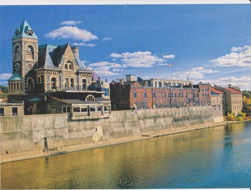 a building with a clock tower next to a body of water at Luxurious town house with x2 Cars Garage no01 in Cambridge