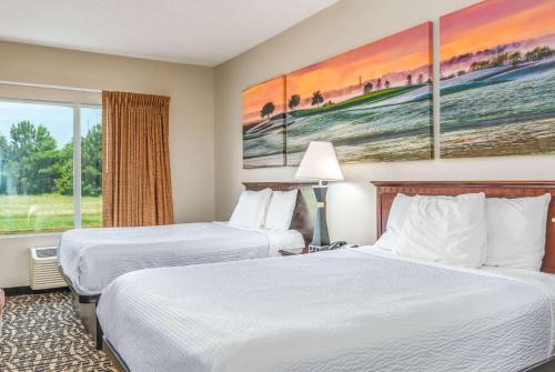 a hotel room with two beds and a window at Days Inn by Wyndham Coliseum Montgomery AL in Montgomery