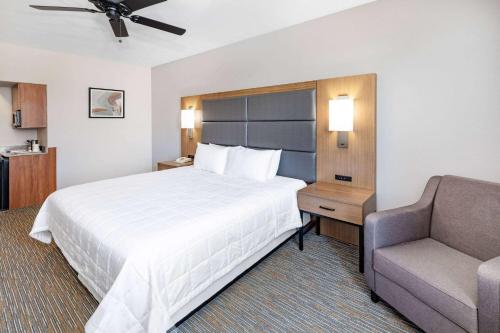 a hotel room with a large bed and a chair at Wingate by Wyndham Houston Bush Intercontinental Airport in Houston