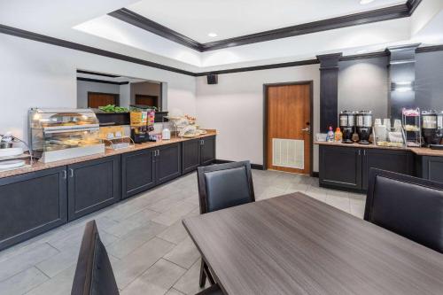 a restaurant with a table and chairs and a counter at Wingate by Wyndham Houston Bush Intercontinental Airport in Houston