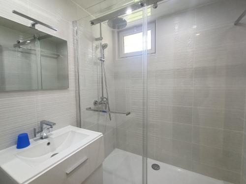 y baño blanco con lavabo y ducha. en Appartement Aix-les-Bains, 2 pièces, 2 personnes - FR-1-555-5, en Aix-les-Bains