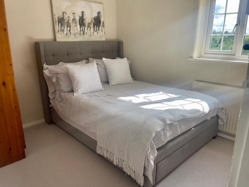a bed with white sheets and pillows in a bedroom at Railway Cottage - Pet friendly with parking in Ripon