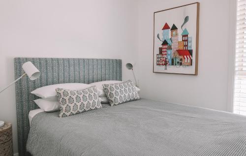 a bedroom with a bed and a picture on the wall at Sunny Corner Holiday Home in Crescent Head