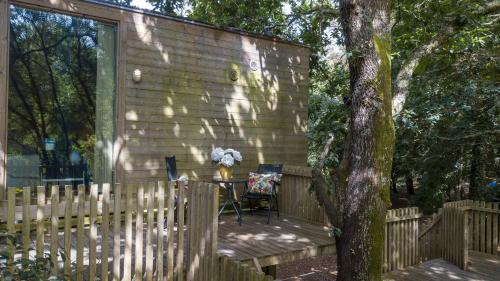 a wooden deck with a table and chairs next to a house at Cabanas de Apriscos in A Coruña