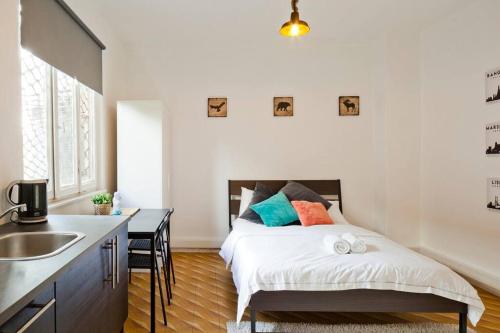 a bedroom with a bed and a kitchen with a sink at Florentine Studio in Tel Aviv
