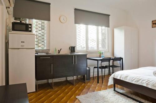 a room with a kitchen and a bed and a table at Florentine Studio in Tel Aviv